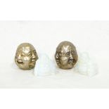 A pair of Oriental opaline glass Buddhas and two white metal quadruple Buddha masks with happy and