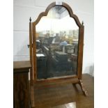 A walnut toilet mirror with domed top, finials to the uprights, on cabriole legs,