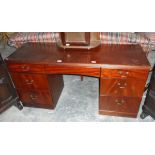 A reproduction mahogany kneehole desk having an arrangement of seven drawers