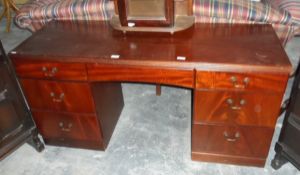 A reproduction mahogany kneehole desk having an arrangement of seven drawers