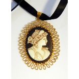 A cameo pendant of female portrait with gold-coloured wrigglework frame and a large silver and Sri