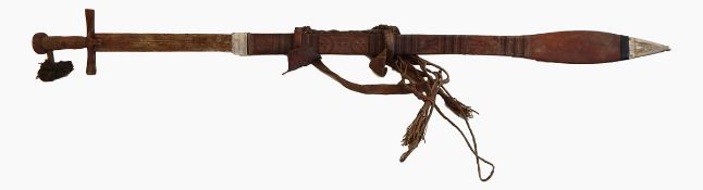 A large African metal sword with wood and leather handle with an embossed and rope decorated