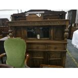 An reproduction oak court cupboard with floral decoration, three short drawers and three cupboards,