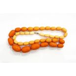A single row of graduated orange bakelite beads