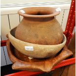 An African terracotta pot with everted rim and incised decoration and two carved wooden bowls (3)