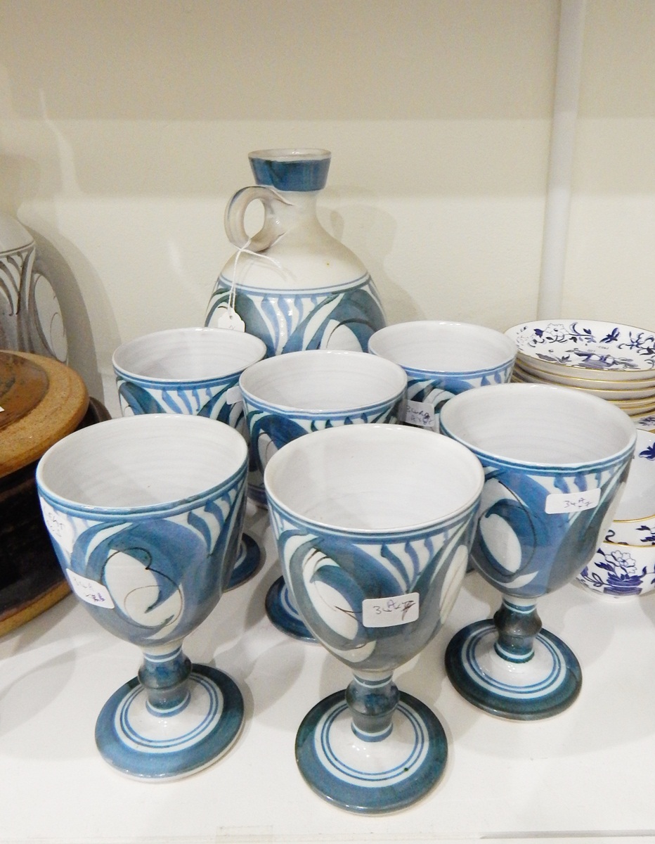 An Aldermaston pottery decanter and six matching goblets painted in blue on grey ground