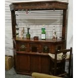 A mahogany style bar complete with two pumps and service optics and two stools,