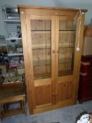 A display cabinet with glass panelled sides and doors,