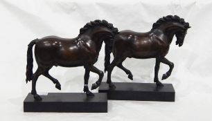 A pair of bronzed-effect resin model prancing horses on plinth bases,