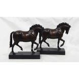 A pair of bronzed-effect resin model prancing horses on plinth bases,