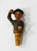 A carved wooden novelty bottle stopper of man with drink nodding his head