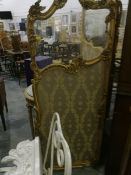A gilt three-fold screen with glass top section and gold and bronze floral pattern,