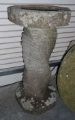 A reconstituted stone bird bath with spirally twisted column,