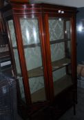 A mahogany display cabinet with stringing borders, two internal shelves,