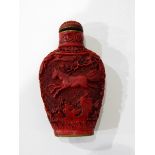 A carved cinnabar lacquer snuff bottle decorated with horses