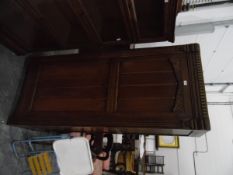 An oak single hanging wardrobe with linenfold press and floral design,
