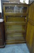 An oak four tier Globe Wernicke-style cabinet with glazed front, on block plinth,