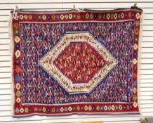 A rug with central cream bordered medallion surrounded by decoration on a blue ground,