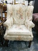 A wingback chair covered in white floral pattern,