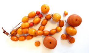 A string of yellow amber beads and large loose orange and yellow amber beads