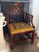A Chippendale style stained fruitwood open armchair with stylised back and arm rests,