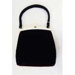 A 1950's Ingber velvet evening bag with brass-coloured fixed frame, one side trimmed with bakelite,