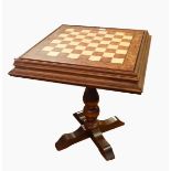 A walnut topped games table with chessboard, on singular column plinth and splayed feet,