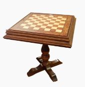 A walnut topped games table with chessboard, on singular column plinth and splayed feet,