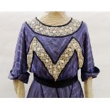 An early Victorian walking dress in purple silk, lace inset sleeves,