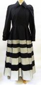 A Jasper Conran black coat dress, full skirted, the skirt banded in silver-coloured material,