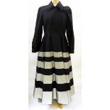 A Jasper Conran black coat dress, full skirted, the skirt banded in silver-coloured material,