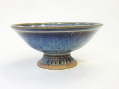 A studio pottery bowl of circular form, on pedestal foot, decorated in a mottled purple glaze,