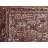An Eastern rug, the central field decorated with botehs, on ivory ground within multiple borders,