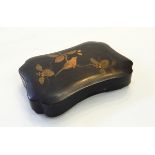 A lacquered box of shaped rectangular form, decorated with a bird on a branch,