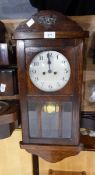 A carved walnut mantel clock with striking movement, a 20th century oak wall clock,