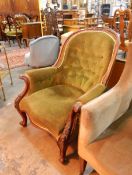 A Victorian button back armchair, with carved walnut frame, floral carved arms,