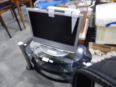 A Sony 17" flatscreen television with remote and a black glass and metal television stand