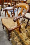 A Victorian walnut armchair, with down swept arms, cane panel seat,