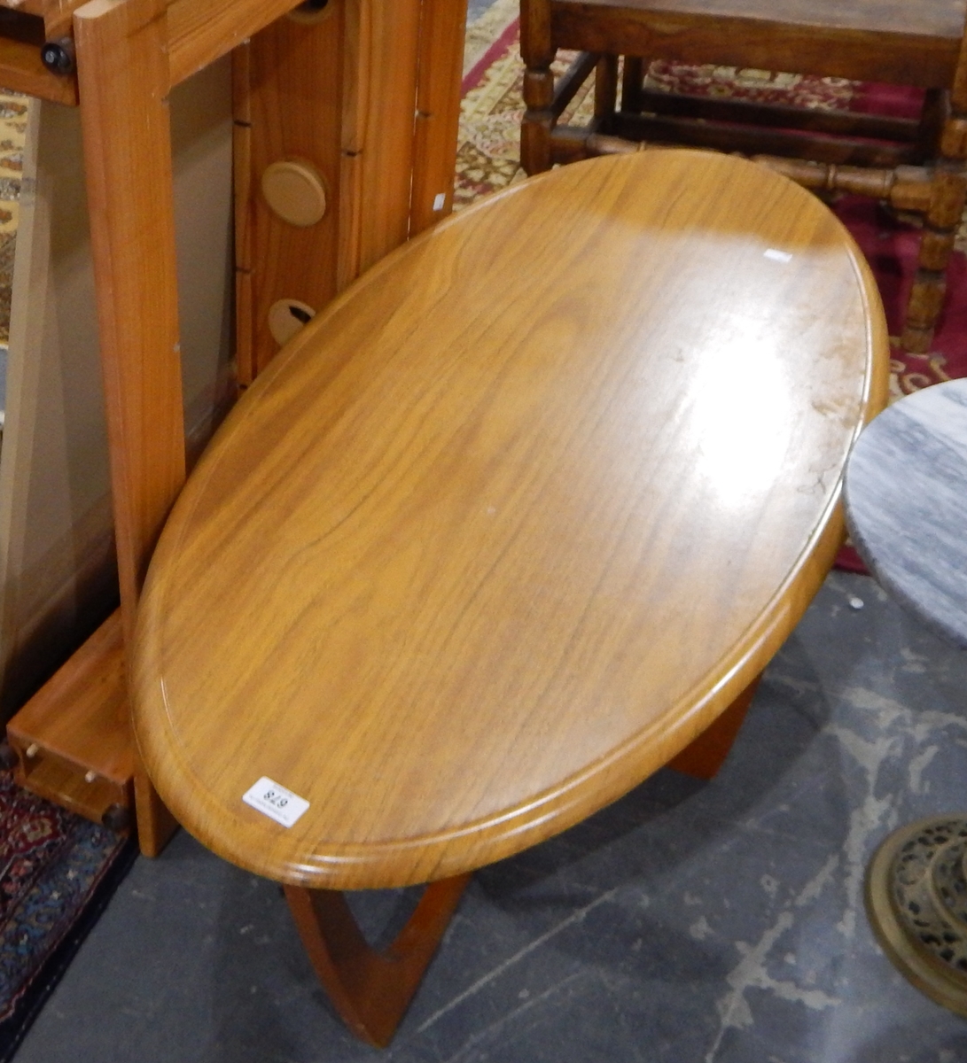 An oval teak-finish coffee table