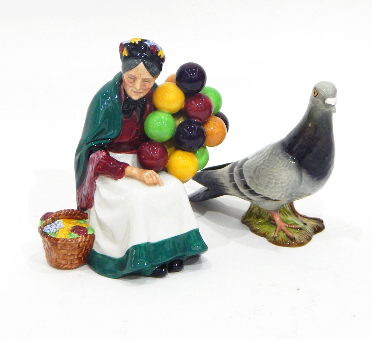 A Royal Doulton figure of 'The Old Balloon Seller' (HN1315), a Beswick model of a pigeon (1383),