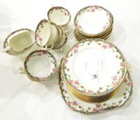 An Aynsley part teaset decorated with border of roses, comprising teacups and saucers, side plates,