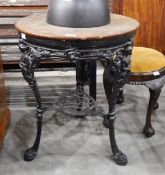 A circular mahogany topped pub table with cast iron ornamental base and with under-tier,