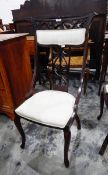 A pair of Edwardian stained as mahogany chairs with fruit and foliate carved crest padded crest