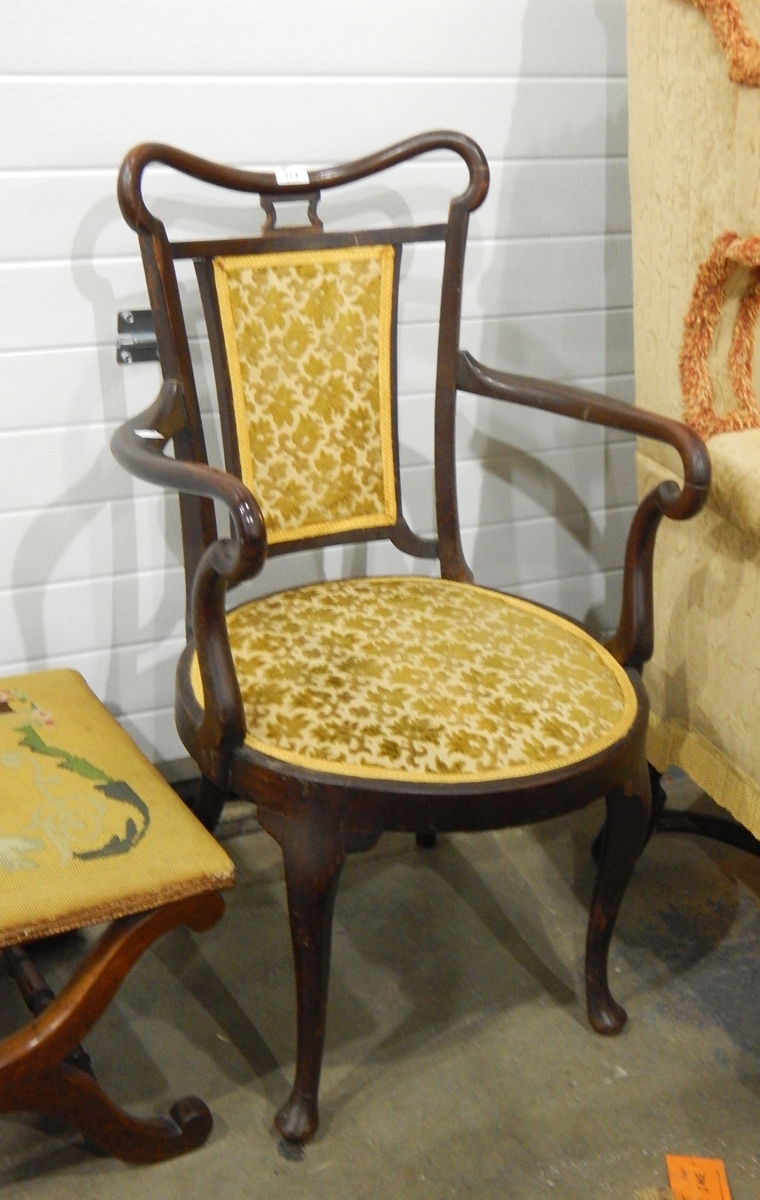 An Edwardian mahogany open armchair, with upholstered panel back,