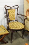 An Edwardian mahogany open armchair, with upholstered panel back,