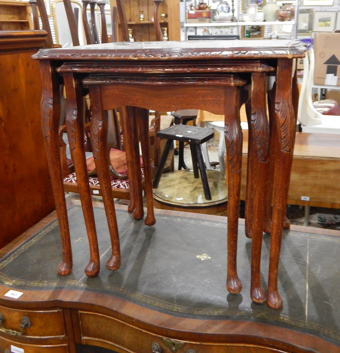 A nest of three mahogany tables with glass inset surfaces