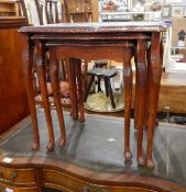 A nest of three mahogany tables with glass inset surfaces