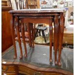 A nest of three mahogany tables with glass inset surfaces