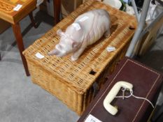 A wicker picnic basket, a carved soapstone model of a rhinoceros,