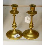 A pair of late Georgian brass candlesticks with knopped stems, on circular bases,